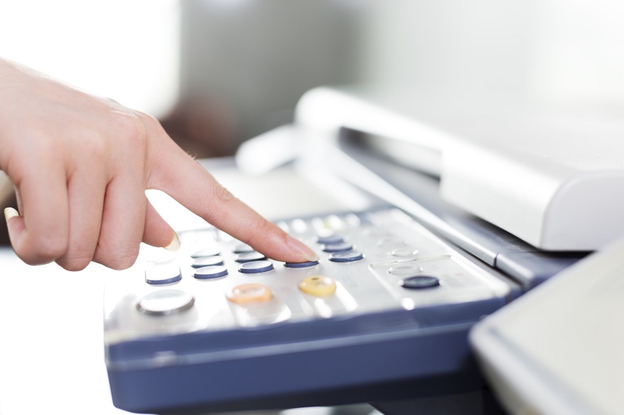 girl's finger presses button of copier